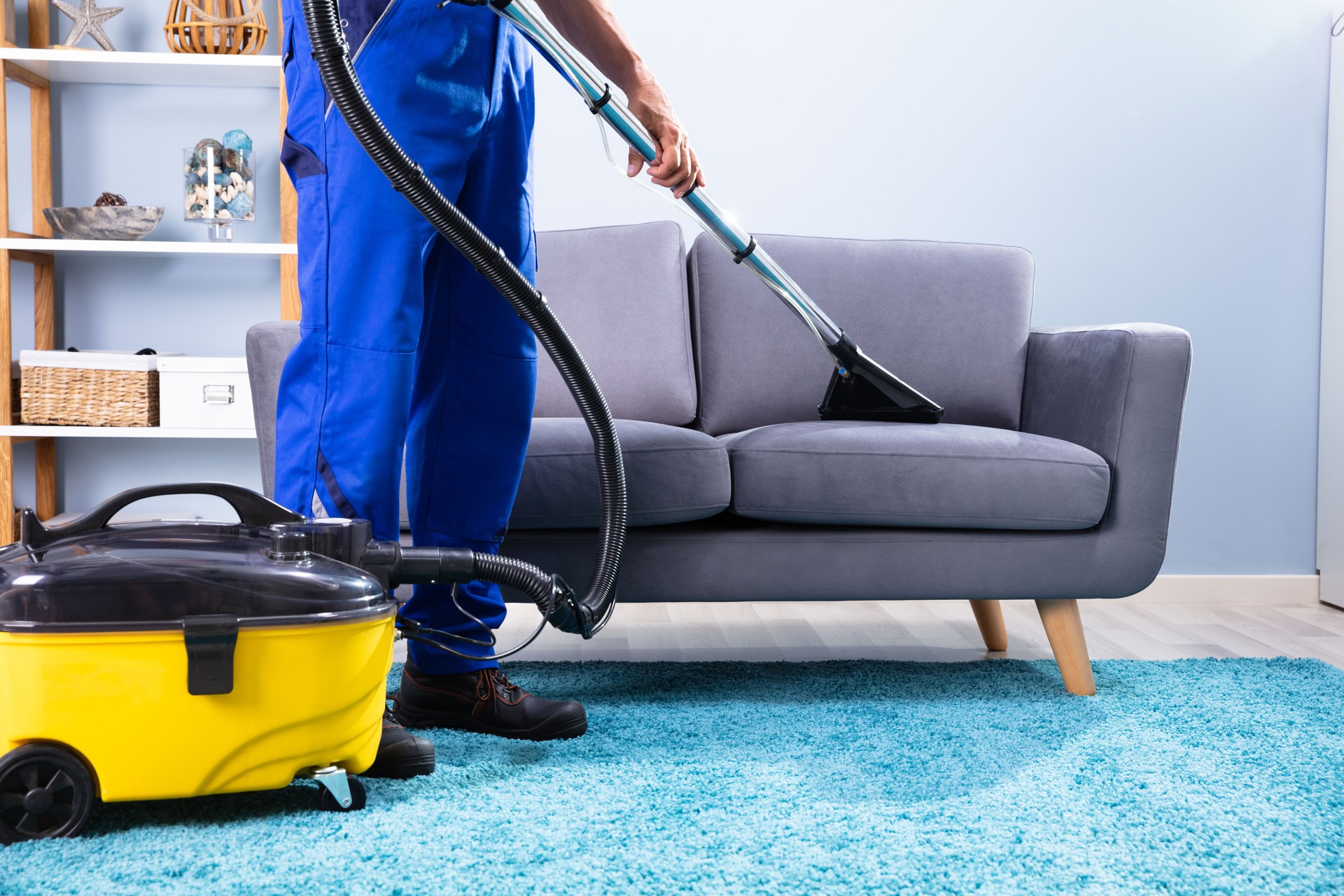 Man Cleaning Sofa With Vacuum Cleaner